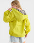 Woman wearing a bright yellow raincoat on a white background