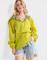 Woman wearing a bright yellow jacket with leopard print trim against a white background