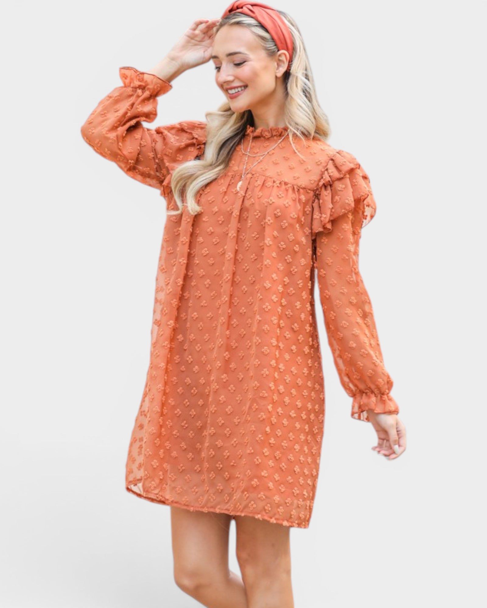 Woman wearing an orange dress with ruffled sleeves on a white background