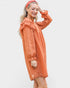 Woman wearing an orange dress with ruffled sleeves on a white background