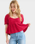 Woman wearing a red top and blue jeans on a white background