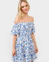 Woman wearing a blue floral off-shoulder dress on a white background