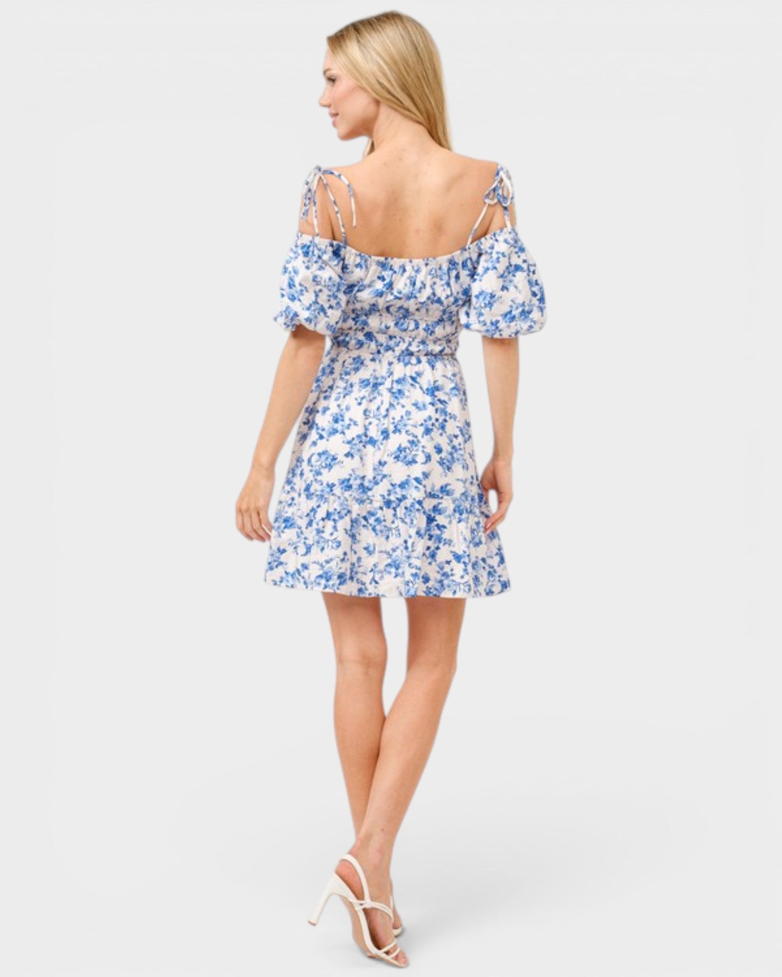 Woman wearing a blue floral dress on a white background