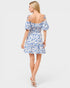 Woman wearing a blue floral dress on a white background