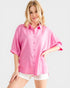 Woman wearing a pink shirt with rolled-up sleeves on a white background