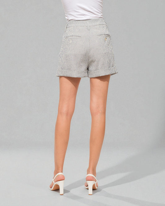 Person wearing light gray shorts on a gray background