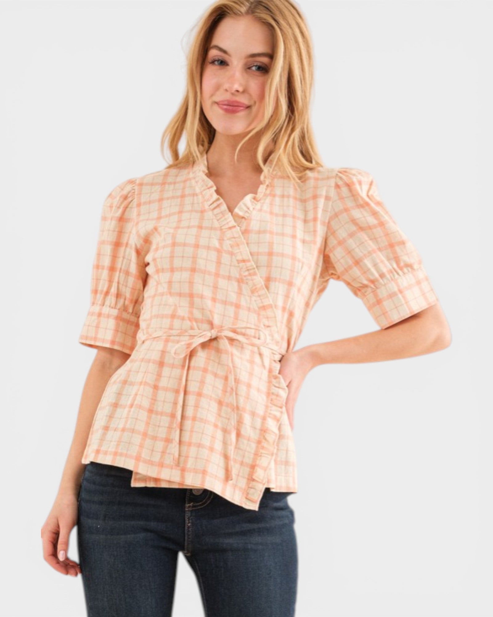 Woman wearing a plaid shirt with a tie waist on a white background