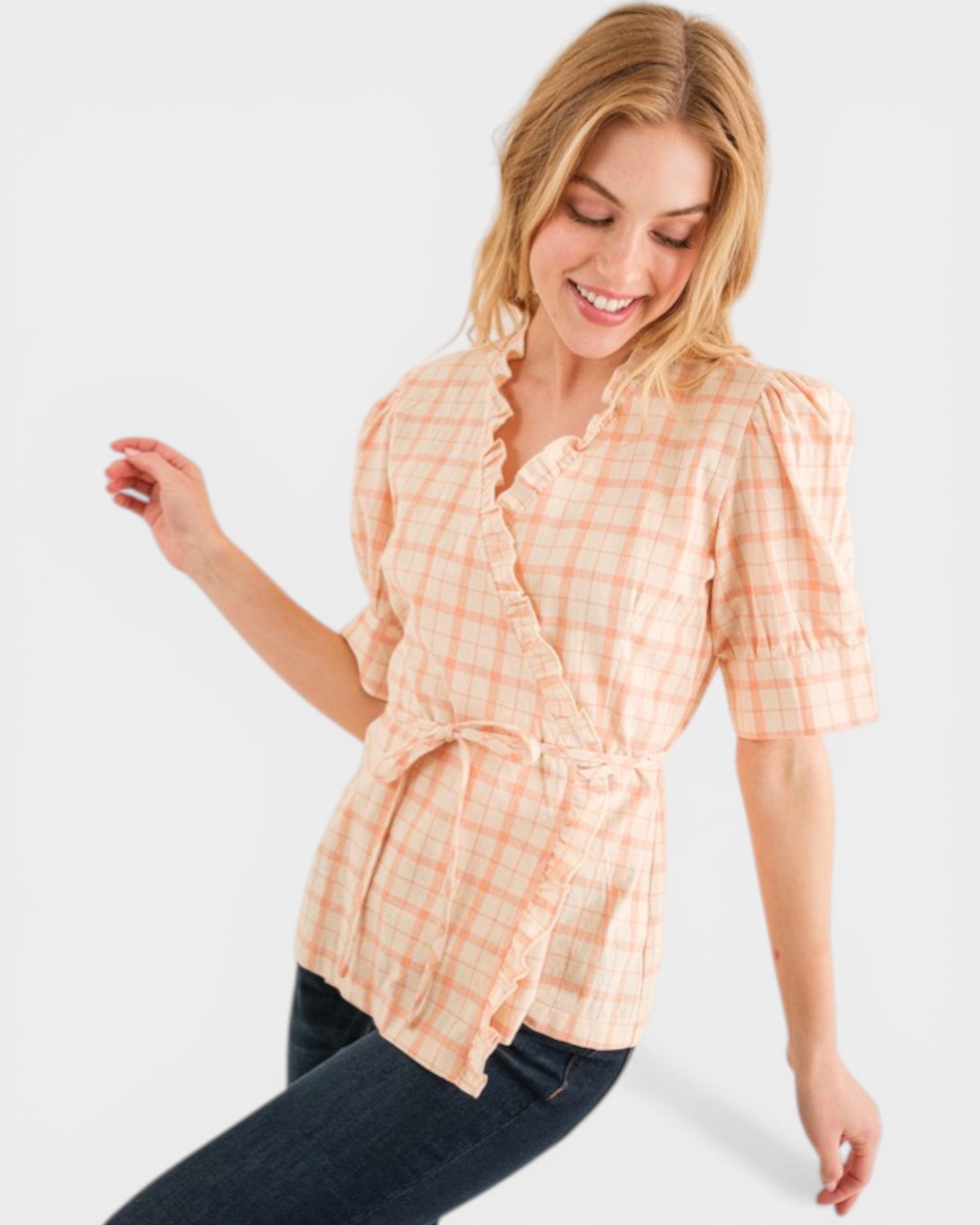 Woman wearing a peach checkered shirt on a white background