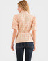 Woman wearing a plaid shirt and dark jeans on a white background