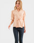 Woman wearing a peach checkered blouse and blue jeans on a white background