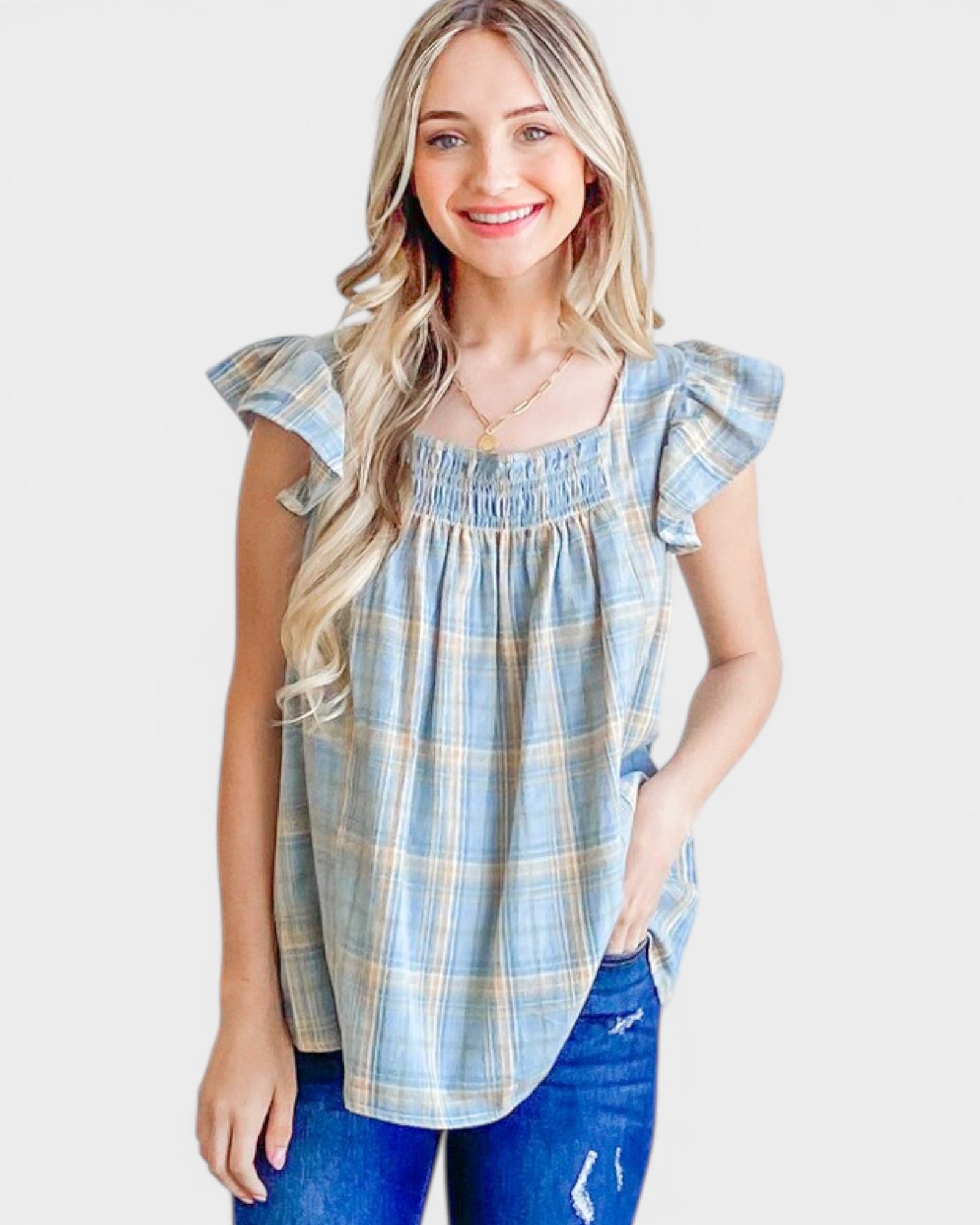 Woman wearing a blue plaid top with ruffled sleeves on a white background