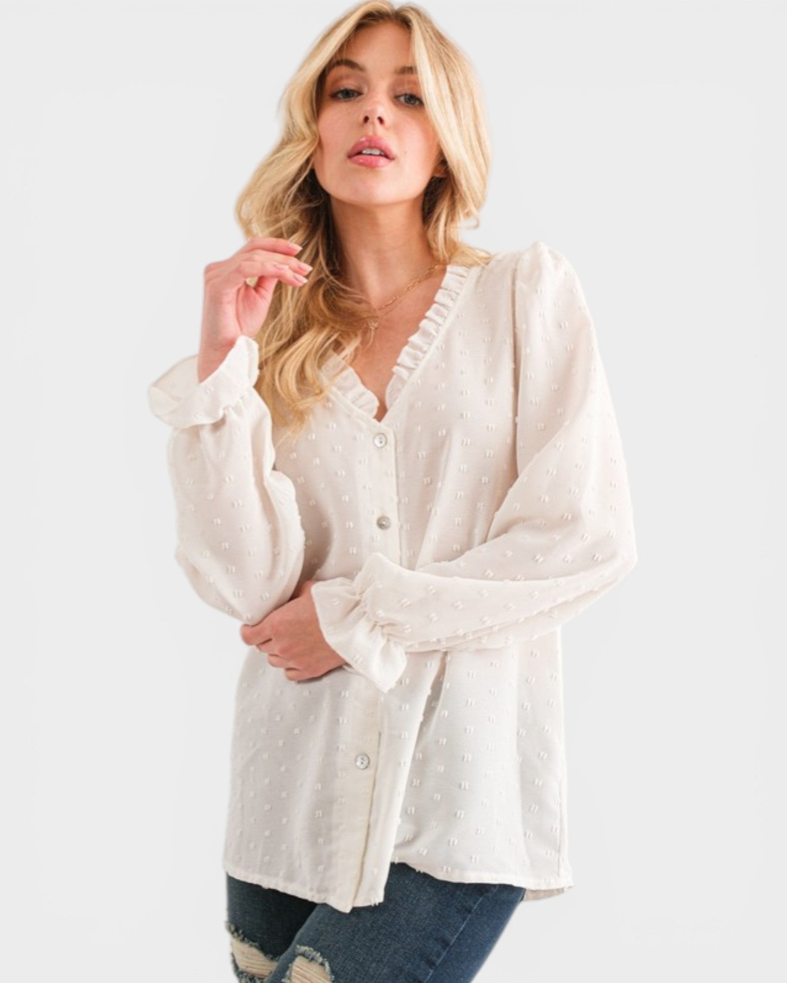 Woman wearing a white blouse with ruffled details on a white background