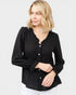 Woman wearing a black long-sleeve top with buttons on a white background