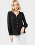 Woman wearing a black long-sleeve top with buttons on a white background