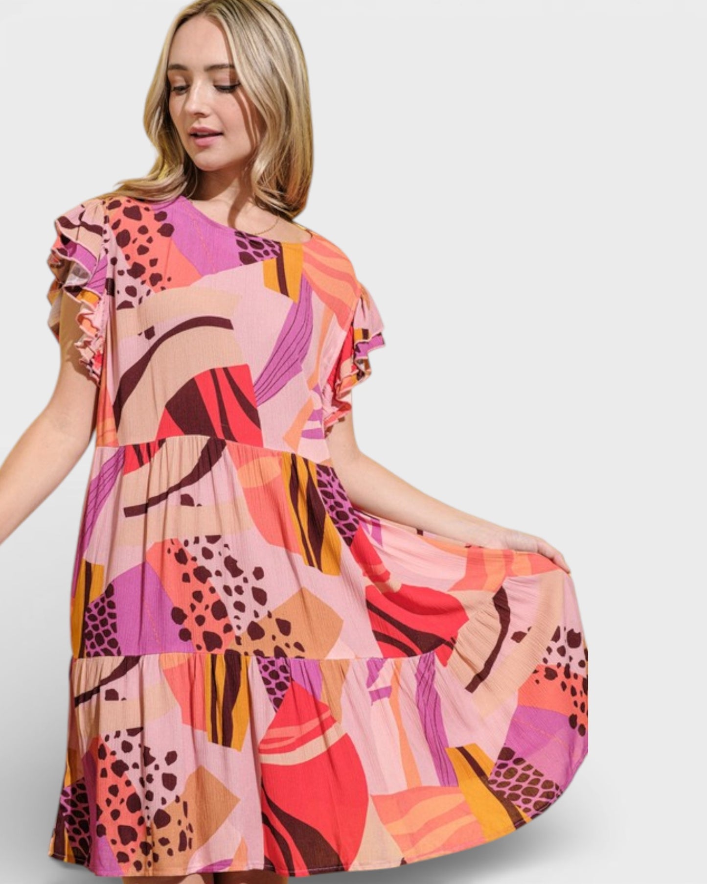 Woman wearing a colorful abstract patterned dress on a white background