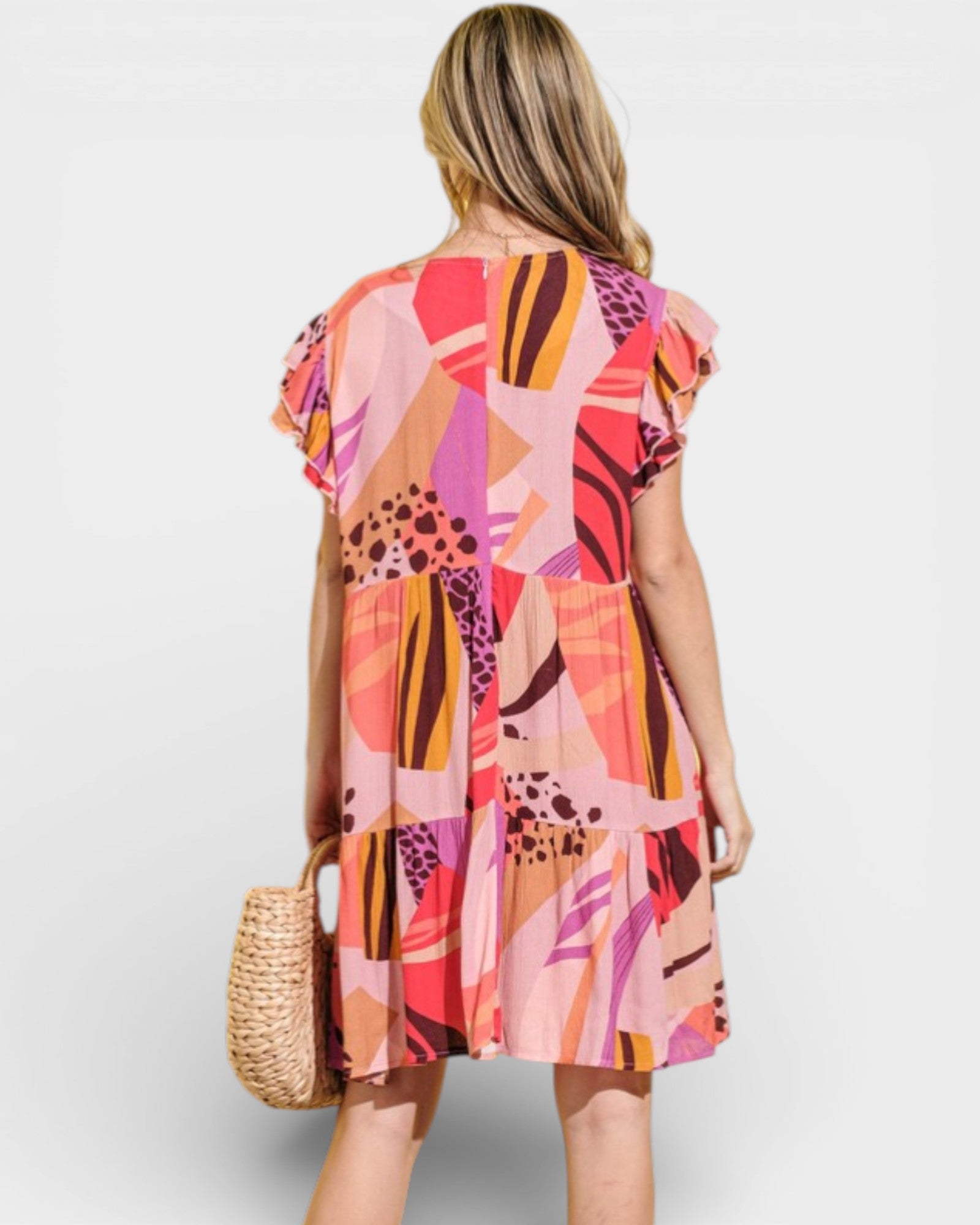 Woman wearing a colorful patterned dress on a white background