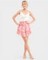 Woman wearing a white top and pink tiered skirt on a white background