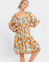 Woman wearing a patterned dress on a white background