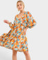 Woman wearing a colorful patterned dress on a white background