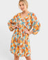 Woman wearing a colorful patterned dress on a white background