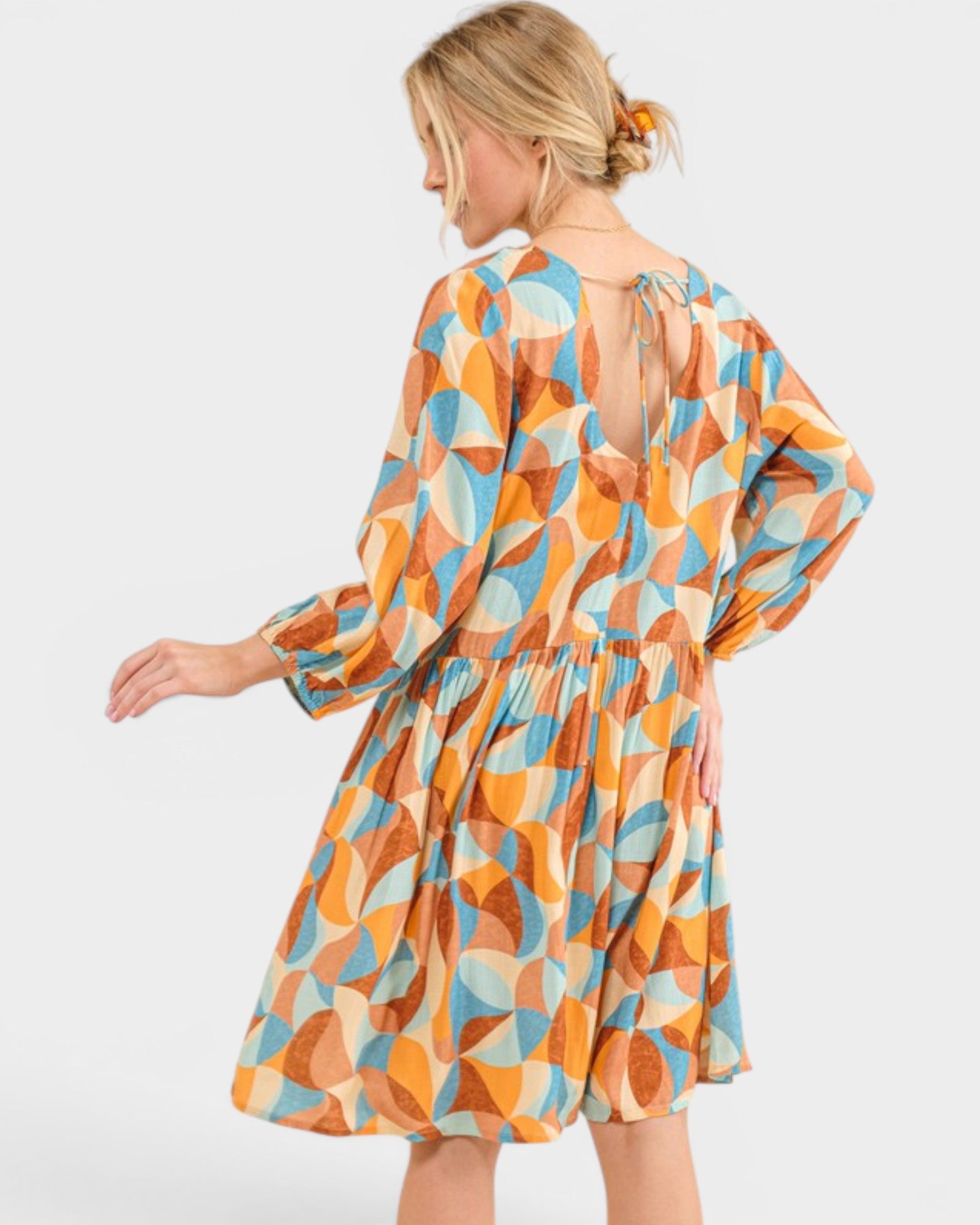 Woman wearing a colorful geometric patterned dress on a white background