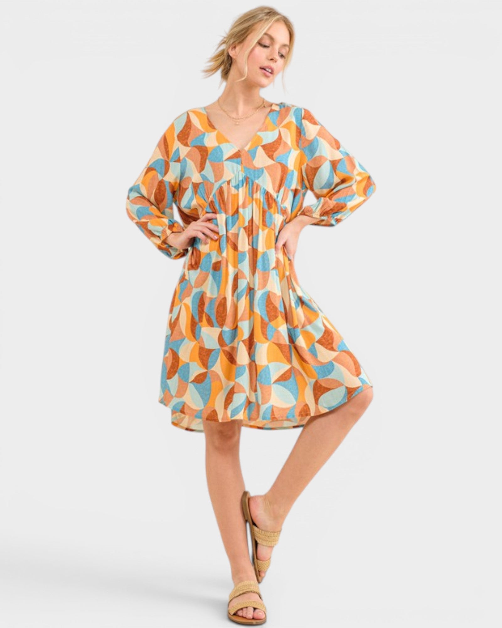 Woman wearing a patterned dress on a plain background