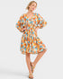Woman wearing a patterned dress on a plain background