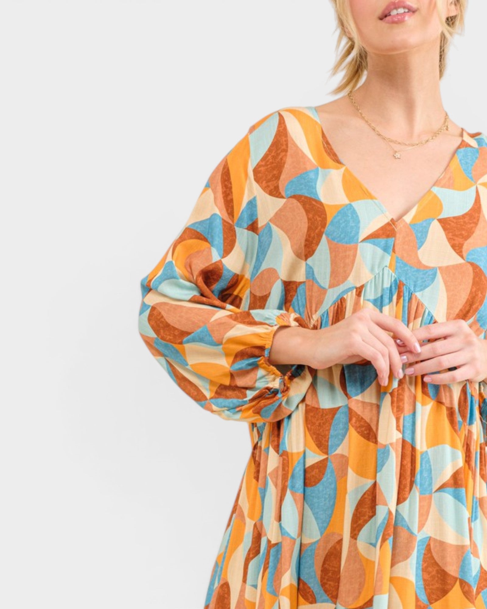Woman wearing a colorful geometric patterned dress on a light gray background
