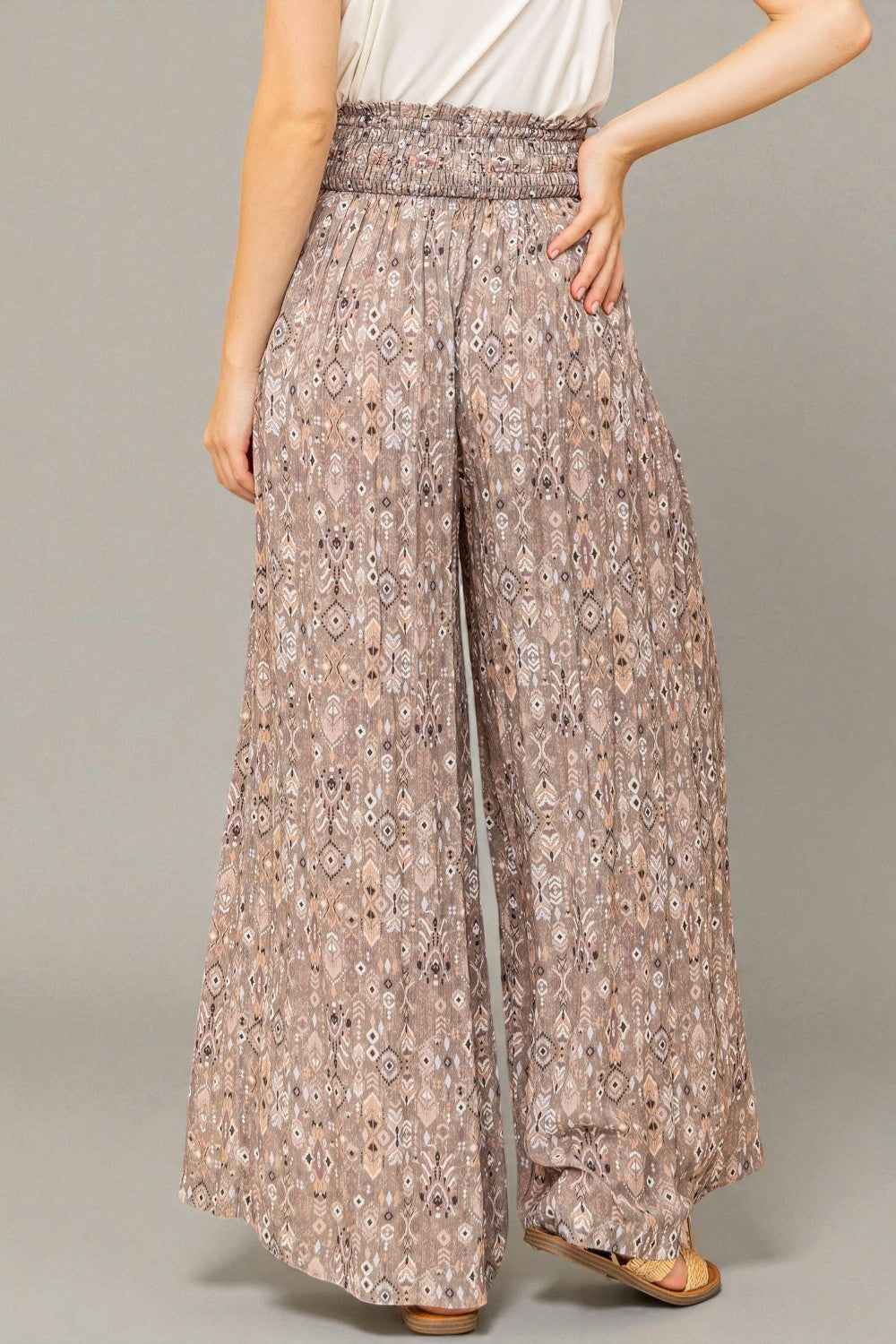 Floral patterned pants worn by a person on a plain background