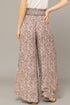 Floral patterned pants worn by a person on a plain background