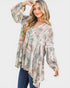 Woman wearing a floral patterned blouse with long sleeves on a white background