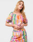 Woman wearing a colorful checkered outfit on a white background