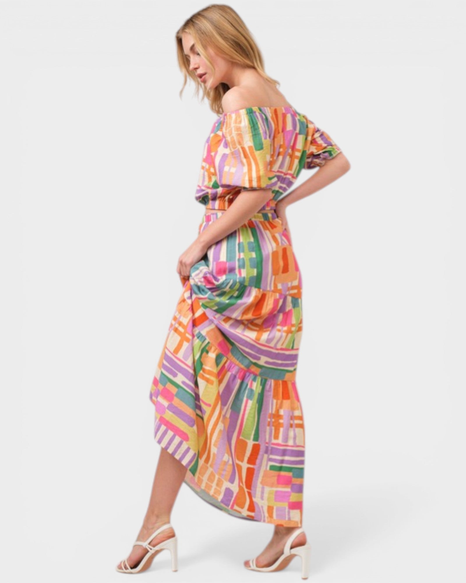 Woman wearing a colorful patterned dress on a white background