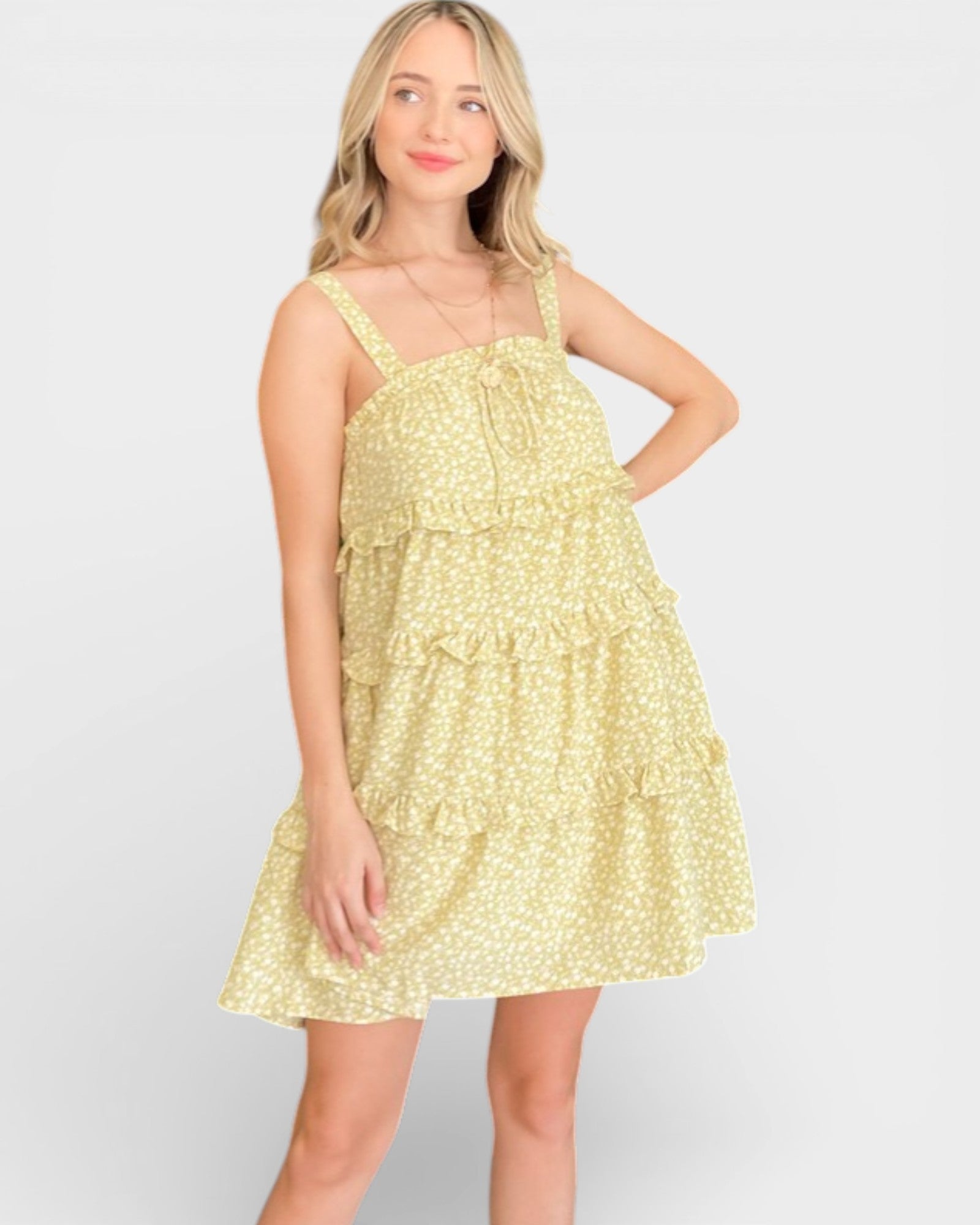 Woman wearing a yellow floral dress on a light gray background