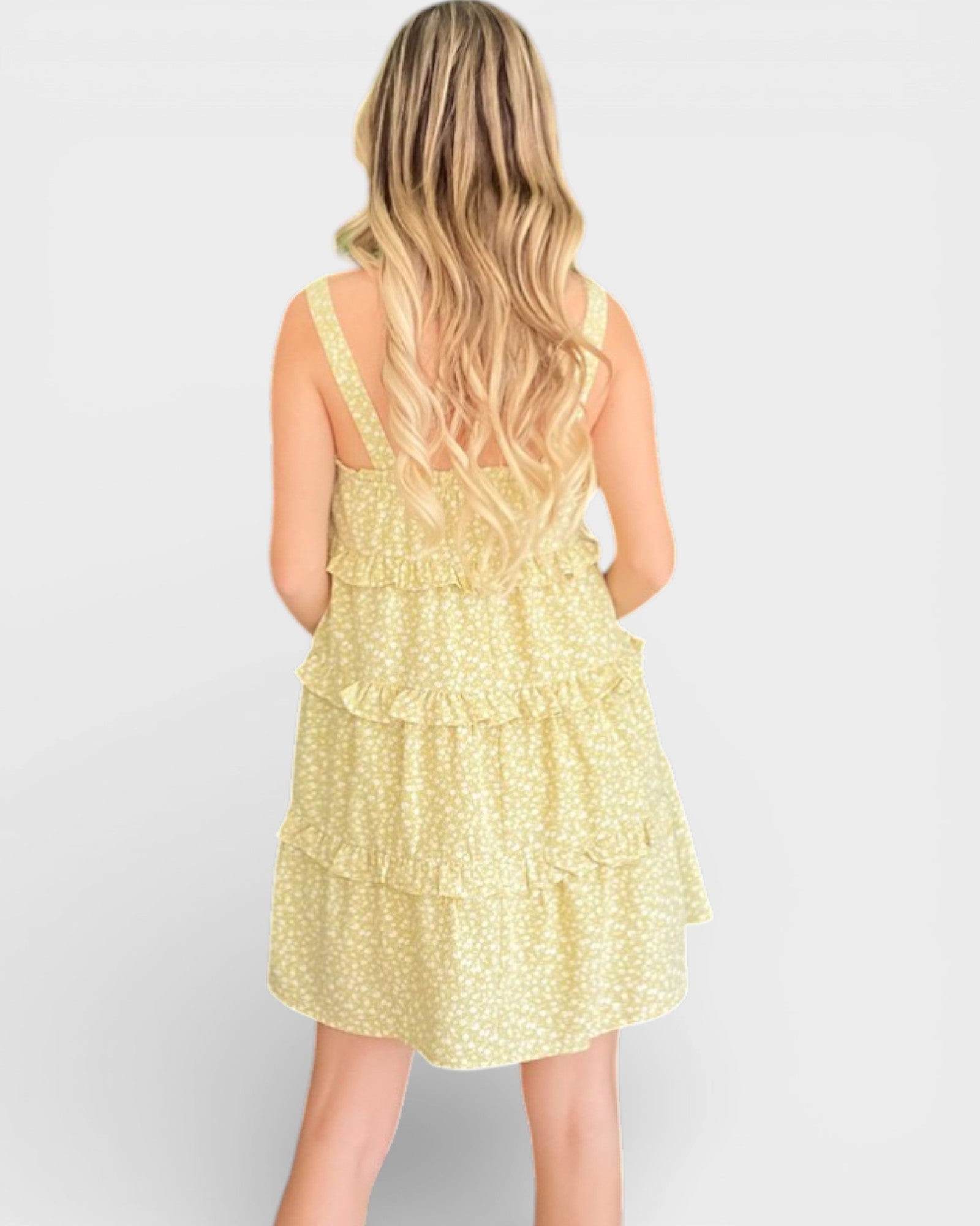 Woman wearing a yellow floral dress on a white background