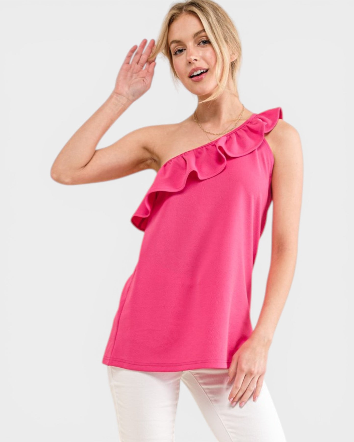 Woman wearing a bright pink one-shoulder top on a white background