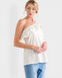 Woman wearing a white one-shoulder top and blue jeans on a white background