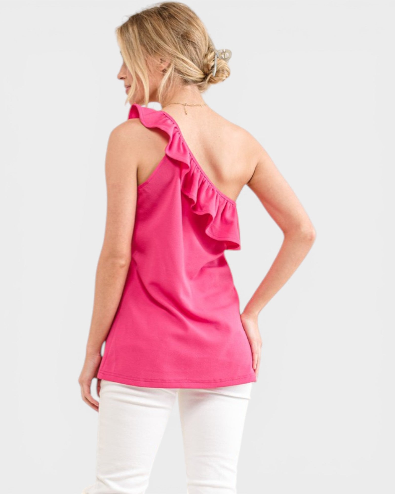 Woman wearing a pink one-shoulder top on a white background