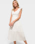 Woman wearing a white dress against a plain background