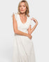 Woman wearing a white dress against a plain background