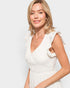 Woman wearing a white dress against a light background