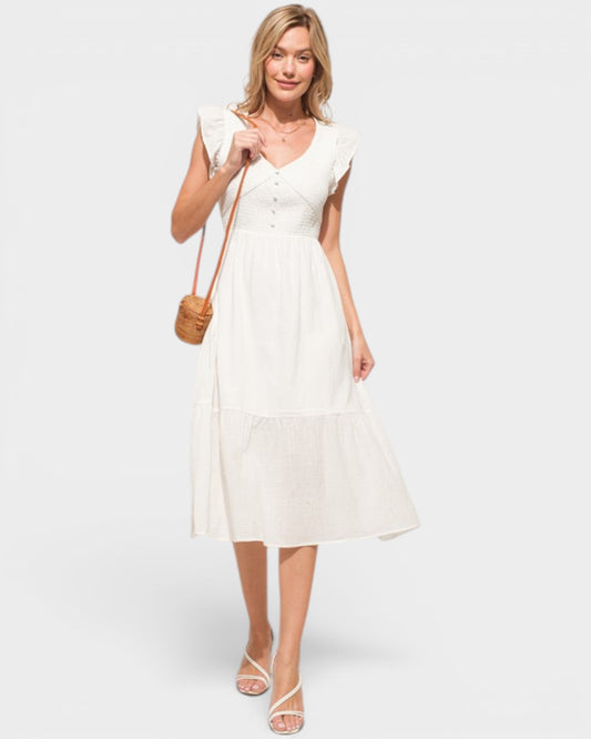 Woman wearing a white dress holding a brown handbag on a white background