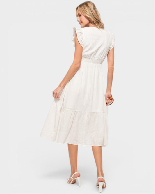 Woman wearing a white dress on a plain background