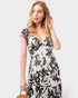 Woman wearing a black and white floral dress on a light gray background