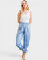 Woman wearing light blue patterned pants and a white top on a white background