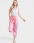 Woman wearing a white top and pink pants on a white background
