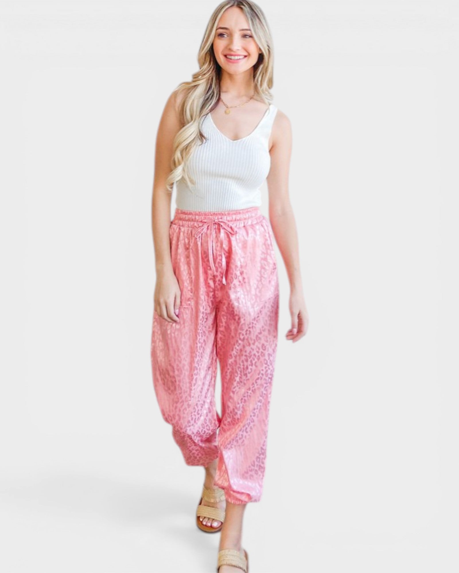 Woman wearing pink pants and a white top on a white background