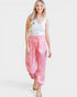 Woman wearing pink pants and a white top on a white background