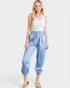 Woman wearing a white top and blue patterned pants on a white background