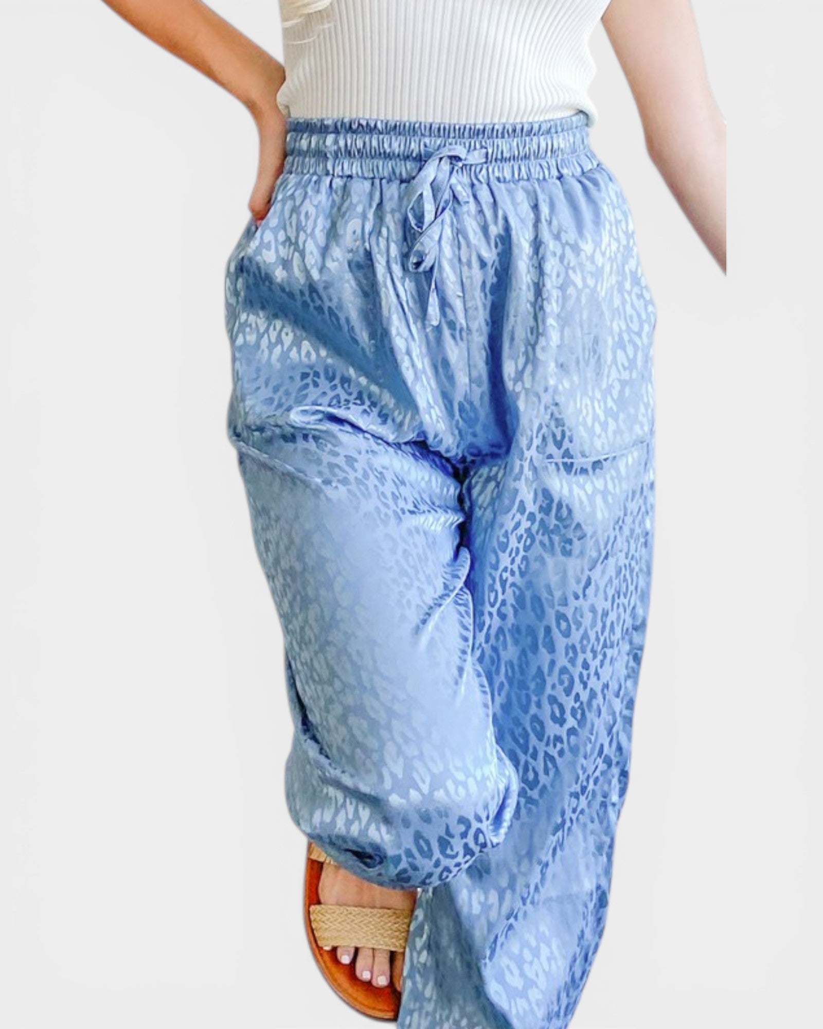 Light blue leopard print pants worn by a person on a white background